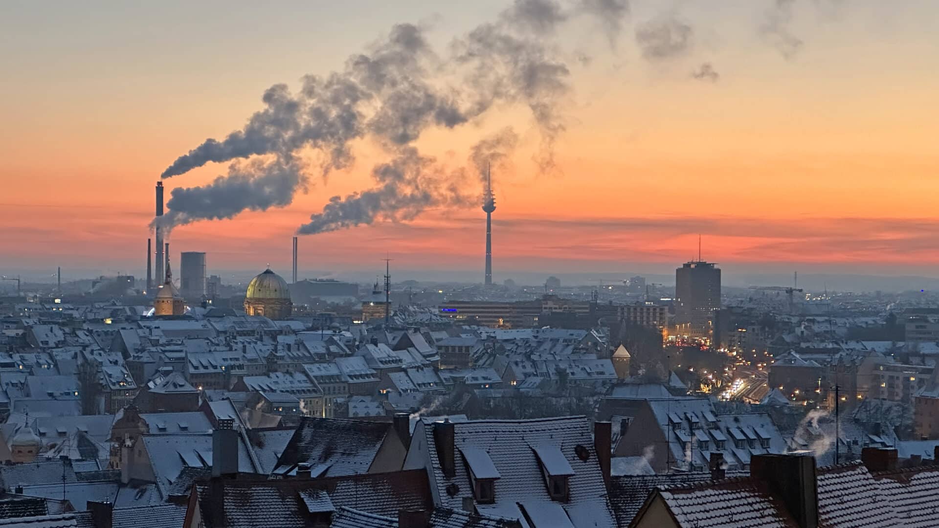 Paisagem urbana do pôr do sol laranja após a queda de neve da noite em Nuremberg com espaço de cópia horizontal
