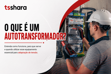 Arte da TS Shara com o título “O que é um autotransformador?”. À direita, um profissional usando capacete e óculos de proteção verifica um painel elétrico com um multímetro, representando o uso do equipamento para adaptação de tensão.